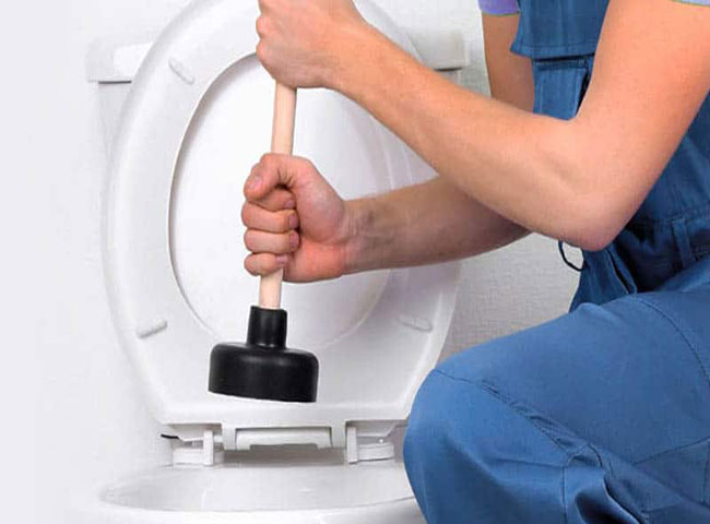 Xử l&yacute; bồn cầu bị ngập nước bằng dụng cụ l&ograve; xo th&ocirc;ng tắc